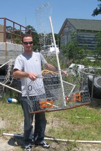 REU student Austin Allen displays a crab pot that he has modified to reduce the inadvertent capture of fish and diamondback terrapins.