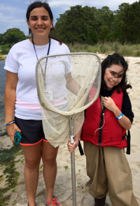 Reporter Layla Rose (R) gets wet and muddy in the York River with VIMS educator Kristen Sharpe.