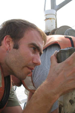 VIMS master's student Patrick Dickhudt examines a sediment sample from the York River.